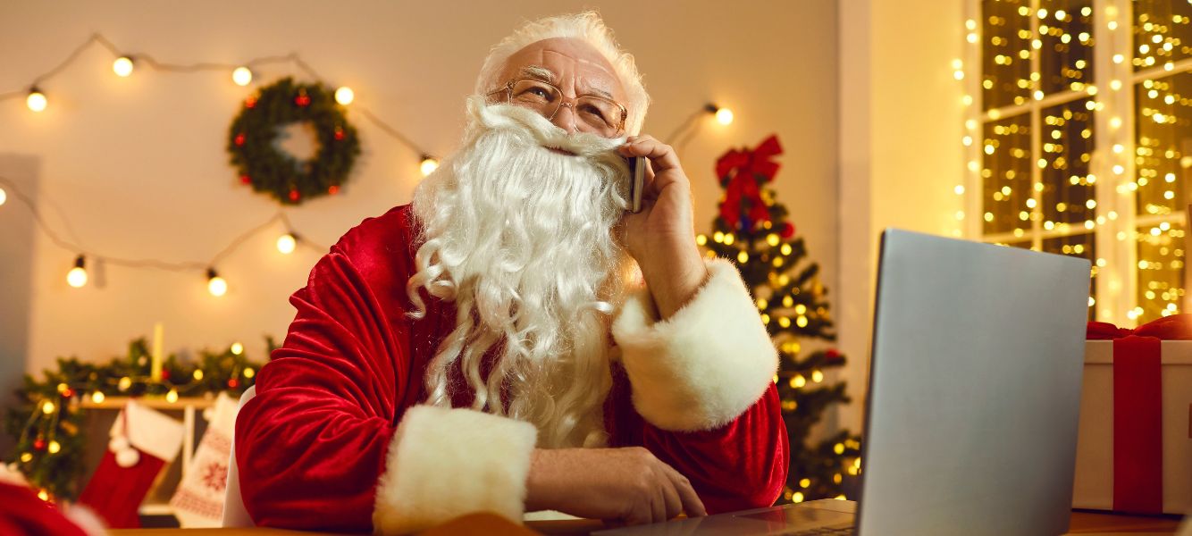 an image of a person dressed as santa claus on the phone looking at a computer for the job search at christmas blog