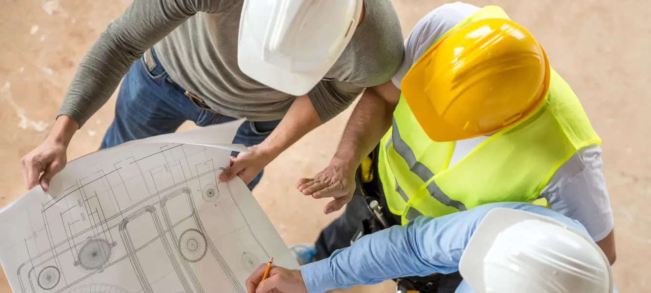 labour market data - a group of engineers standing around a blueprint