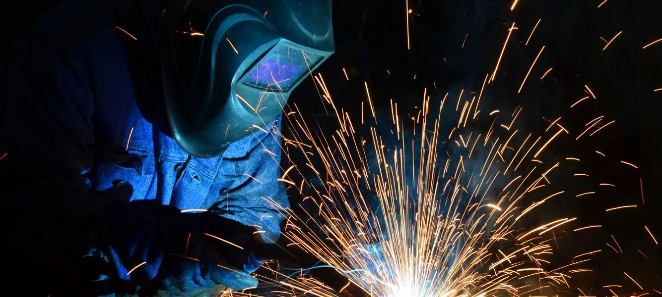 An image of a person welding material on the Astute People blog about labour market statistics