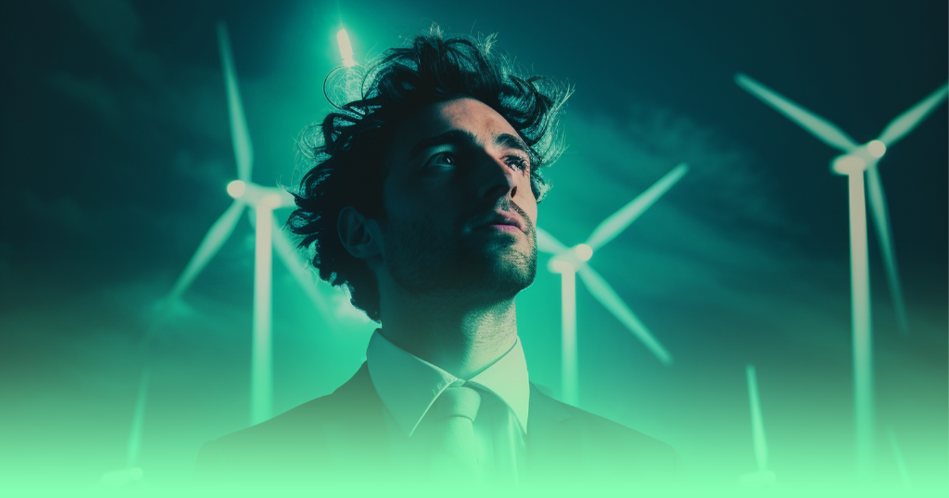 An image of a man staring upwards while standing in front of wind turbines