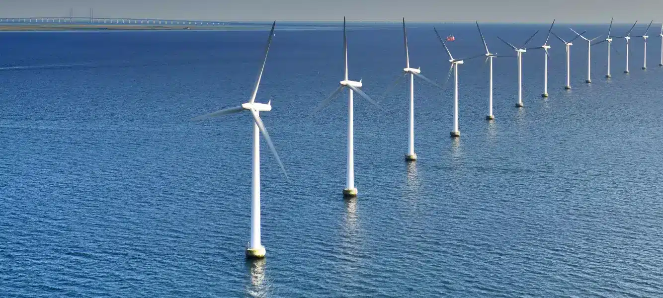 an image of multiple off shore wind turbines for a blog about 5 benefits of renewables