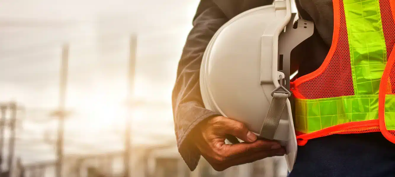 An EHS Manager standing with a hardhat in his hands